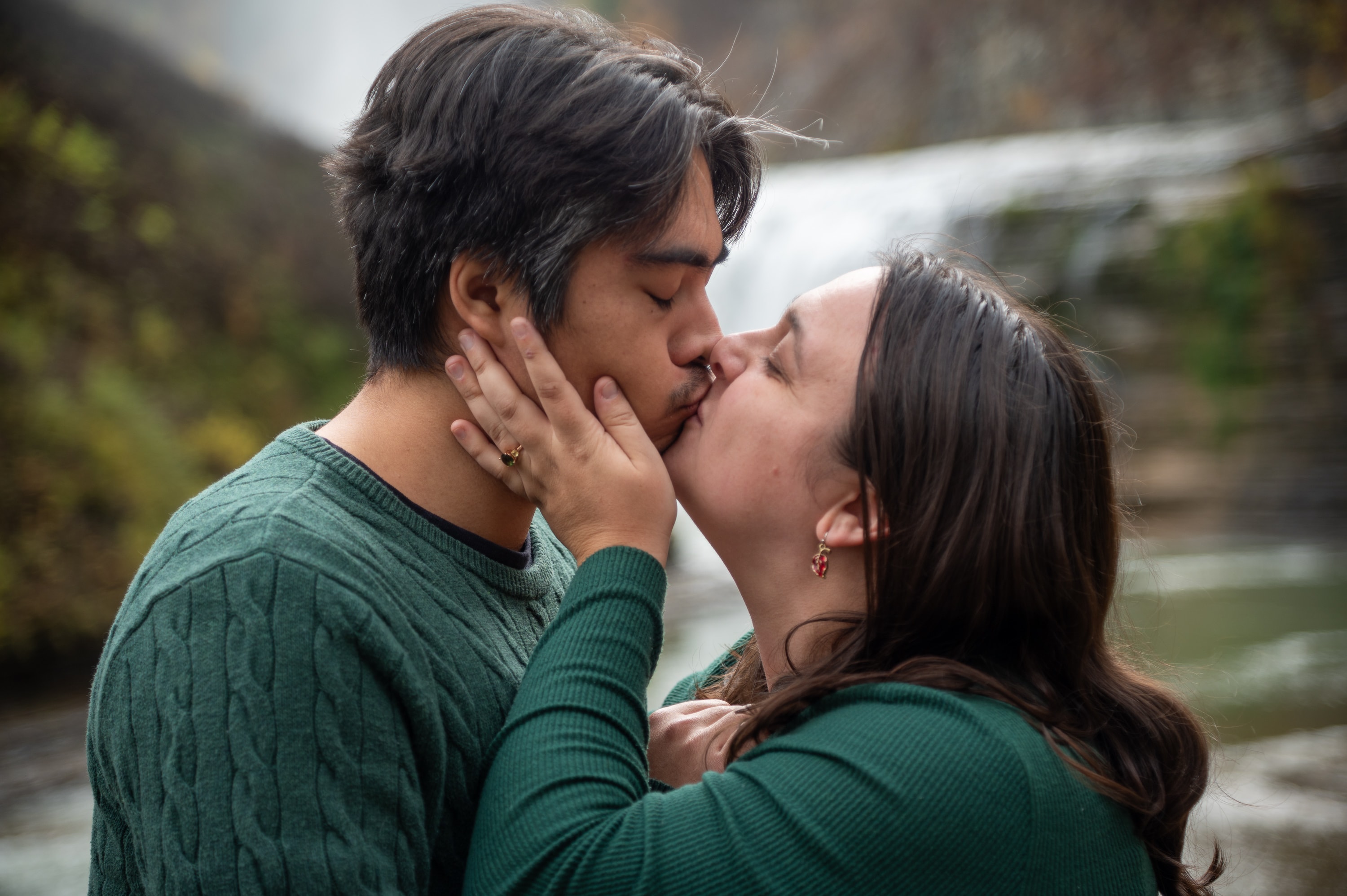 Couple kissing by waterfall outdoors
